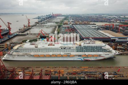 Schanghai. 6. Juni 2023. Dieses Luftfoto wurde am 6. Juni 2023 aufgenommen und zeigt Chinas erstes großes Kreuzfahrtschiff „Adora Magic City“ im Osten Chinas Shanghai. Chinas erstes im Inland gebautes großes Kreuzfahrtschiff schloss sein Abdocken in Shanghai am Dienstag ab und markiert damit seinen vollständigen Übergang zur Phase des Debugging-Anlegens am Dock. Das Kreuzfahrtschiff „Adora Magic City“ wird voraussichtlich Ende 2023 geliefert. Kredit: Ding Ting/Xinhua/Alamy Live News Stockfoto