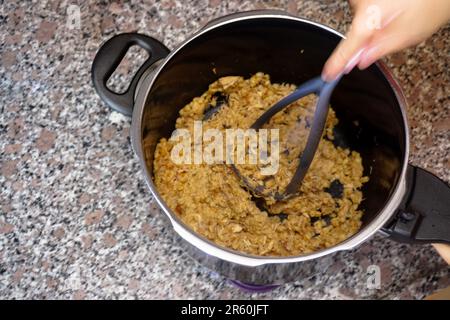 Die berühmte osmanische Mahlzeit Keskek wird zu Hause in der Küche mit Getreide und Huhn zubereitet Stockfoto