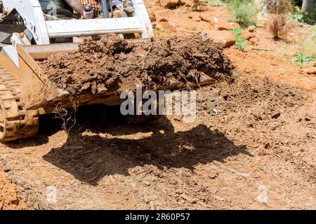 Für die Durchführung von Bauverbesserungsarbeiten wird der ausgewiesene Standort durch den Einsatz des Traktors Territorium anlegen Stockfoto