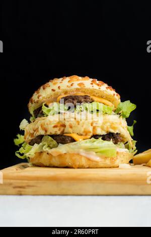 Ein frisch zubereiteter Burger auf einem Holzbrett. Stockfoto