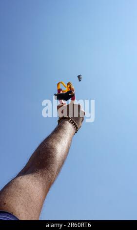 Ein Mann mit Speerwerfer, der Naturunterhaltung mit Steinen wirft Stockfoto