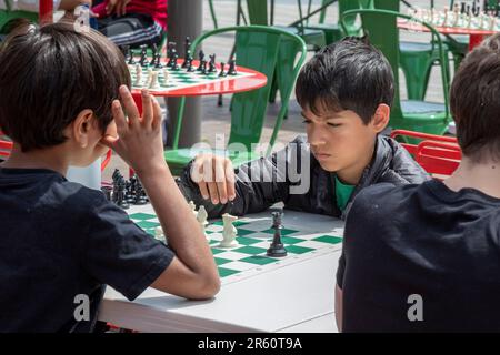 Washington, DC: Kinder spielen Schach auf der Eastern Market Metro Plaza am Capitol Hill. Das Schachturnier wurde von den USA organisiert Schachzentrum. Stockfoto