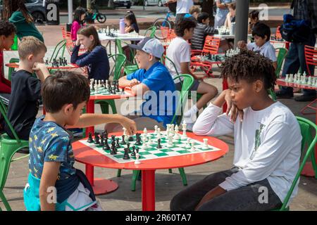 Washington, DC: Kinder spielen Schach auf der Eastern Market Metro Plaza am Capitol Hill. Das Schachturnier wurde von den USA organisiert Schachzentrum. Stockfoto