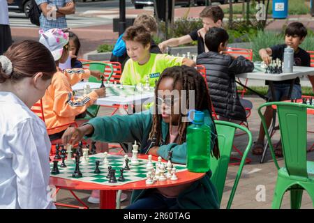 Washington, DC: Kinder spielen Schach auf der Eastern Market Metro Plaza am Capitol Hill. Das Schachturnier wurde von den USA organisiert Schachzentrum. Stockfoto