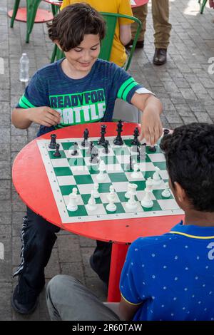 Washington, DC: Kinder spielen Schach auf der Eastern Market Metro Plaza am Capitol Hill. Das Schachturnier wurde von den USA organisiert Schachzentrum. Stockfoto