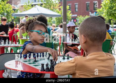 Washington, DC: Kinder spielen Schach auf der Eastern Market Metro Plaza am Capitol Hill. Das Schachturnier wurde von den USA organisiert Schachzentrum. Stockfoto