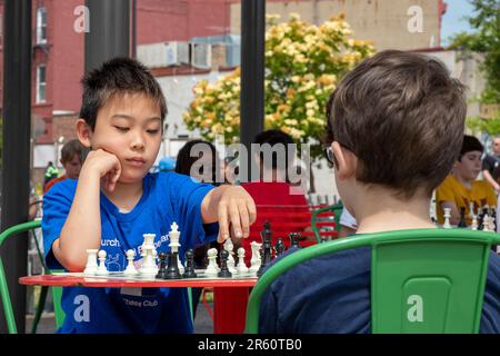 Washington, DC: Kinder spielen Schach auf der Eastern Market Metro Plaza am Capitol Hill. Das Schachturnier wurde von den USA organisiert Schachzentrum. Stockfoto