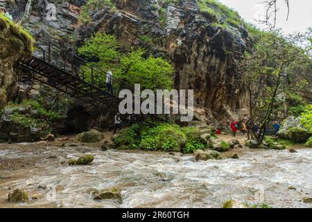 Karachay-Cherkessia, Russland - 8. Mai 2023: Honigwasserfälle, Touristen gehen die Treppe. Honigwasserfälle sind eine Gruppe von Wasserfällen auf der Alikonovka Stockfoto