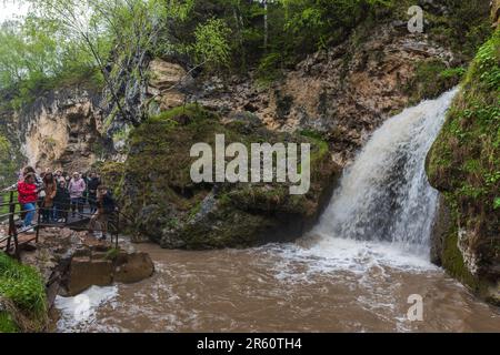 Karachay-Tscherkesien, Russland - 8. Mai 2023: Touristen sind in der Nähe des Wasserfalls. Honigwasserfälle sind eine Gruppe von Wasserfällen auf Alikonovka und Echki-Bas Stockfoto