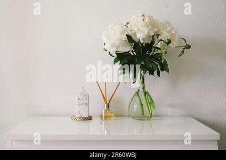 Räucherstäbchen und Vase mit weißen Pfingstrosen. Umweltfreundlicher Duft für Ihr Zuhause Stockfoto