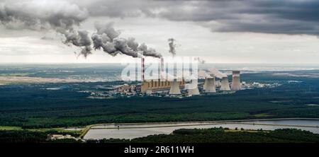 Aus der Vogelperspektive: Kraftwerk, Rauch aus Schornsteinen und Kohlebergwerk in Belchatow unter launischem, wolkigen Himmel, Polen Stockfoto