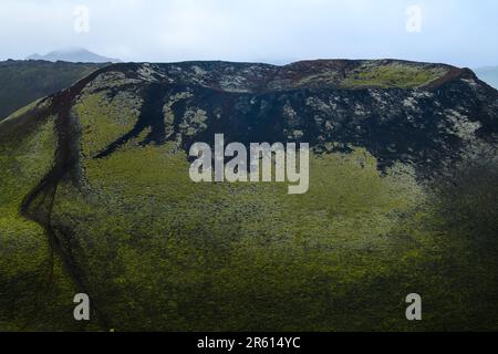 Eine malerische Landschaft mit einer Bergkette, bedeckt von üppigem grünen Gras, Island Stockfoto