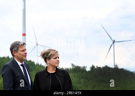 06. Juni 2023, Nordrhein-Westfalen, Bad Berleburg: Robert Habeck (l), Bundesminister für Wirtschaft, und die Wirtschaftsministerin Mona Neubaur (beide Grüne) des NRW stehen zur Stromerzeugung vor Windturbinen. Die Wittgenstein-Gruppe und der NRW State Association for Renewable Energies beauftragen offiziell den Waldwindpark Arfeld mit vier Windturbinen, der seit Herbst 2022 in Betrieb ist. Foto: Federico Gambarini/dpa Stockfoto