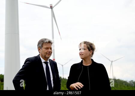 06. Juni 2023, Nordrhein-Westfalen, Bad Berleburg: Robert Habeck (l), Bundesminister für Wirtschaft, und die Wirtschaftsministerin Mona Neubaur (beide Grüne) des NRW stehen zur Stromerzeugung vor Windturbinen. Die Wittgenstein-Gruppe und der NRW State Association for Renewable Energies beauftragen offiziell den Waldwindpark Arfeld mit vier Windturbinen, der seit Herbst 2022 in Betrieb ist. Foto: Federico Gambarini/dpa Stockfoto