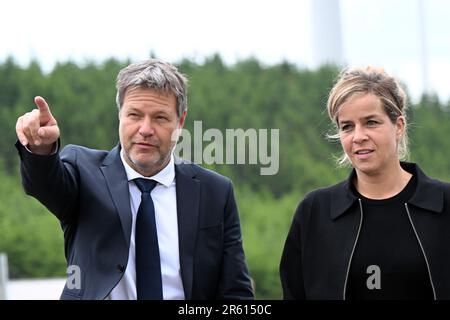 06. Juni 2023, Nordrhein-Westfalen, Bad Berleburg: Robert Habeck (l), Bundesminister für Wirtschaft, und die Wirtschaftsministerin Mona Neubaur (beide Grüne) des NRW stehen zur Stromerzeugung vor Windturbinen. Die Wittgenstein-Gruppe und der NRW State Association for Renewable Energies beauftragen offiziell den Waldwindpark Arfeld mit vier Windturbinen, der seit Herbst 2022 in Betrieb ist. Foto: Federico Gambarini/dpa Stockfoto