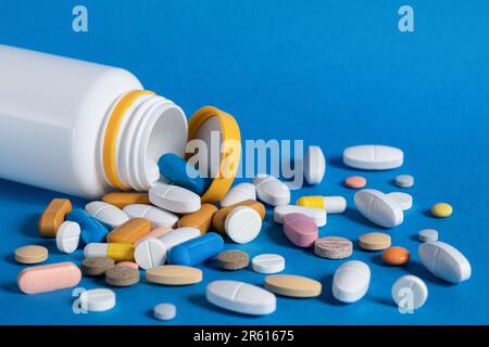 Viele Pillen, verschiedene Formen und Farben auf blauem Hintergrund. Medizinische und pharmazeutische Behandlungskonzepte. Speicherplatz kopieren Stockfoto