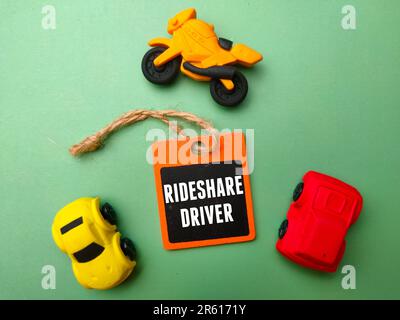 Nahaufnahme von drei Miniatur-Spielzeugautos, die neben einem Schild mit der Aufschrift „Fahrer“ geparkt sind Stockfoto