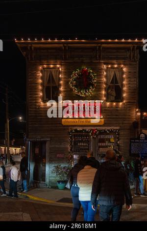 St. Augustine, Florida - 30. Dezember 2022: Menschenmassen gehen in Richtung Potters Wax Museum während der berühmten Nächte der Lichter zu Weihnachten Stockfoto