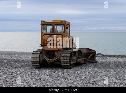 Gelber Bulldozer an einem leeren Strand Stockfoto