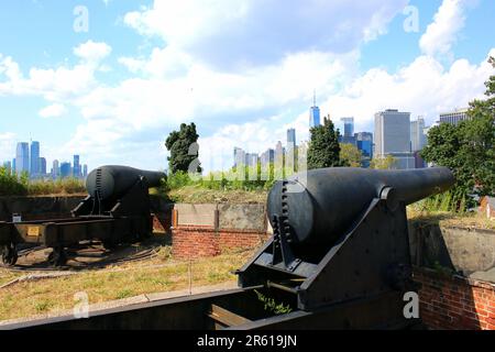 10- und 15-Zoll-Rodman-Artilleriekanonen von 1861, die Fort Jay auf Governors Island bewachen, mit Lower Manhattan und der Skyline von New Jersey City im Hintergrund Stockfoto