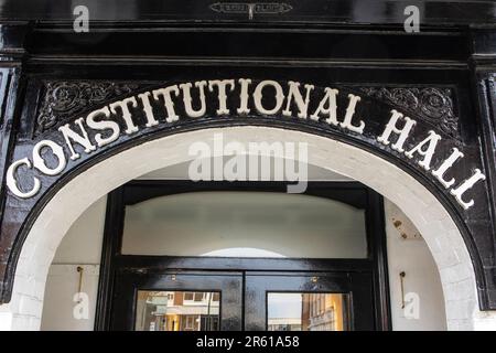 Ein Oldtimer-Schild über dem Eingang zur ehemaligen Verfassungshalle in der historischen Stadt Guildford in Surrey, Großbritannien. Stockfoto