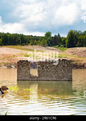 Alte Häuser eines Dorfes im Sau Reservoir in Katalonien während der Dürre. Dürre in Spanien, Umweltprobleme. Stockfoto