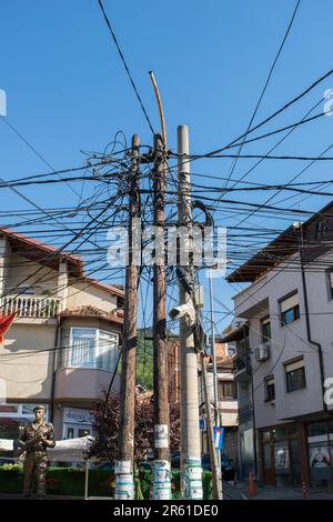 In Prizren, im Kosovo, im ehemaligen Jugoslawien, hat sich eine verworrene Masse von Stromkabeln und Stromkabeln an einer Straßenecke aneinander gerüttelt Stockfoto