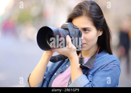 Professioneller Fotograf, der mit einer professionellen dslr-Kamera Fotos auf der Straße macht Stockfoto