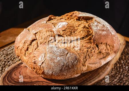 Frisch gebackenes Roggenbrot auf dem Tisch, Nahaufnahme, selektiver Fokus. Hausgemachtes Brot mit Vollkornmehl. Produkte aus dem Betrieb Stockfoto