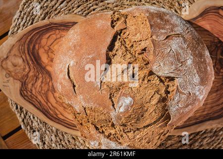 Frisch gebackenes hausgemachtes graues Brot, Draufsicht, Vollkornbrot auf einem Schneidebrett, Bauernprodukte, handwerklich köstliches Brot Stockfoto