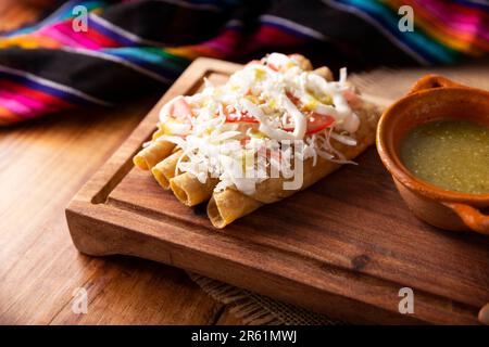 Tacos Dorados. Mexikanisches Gericht, auch bekannt als Flautas, besteht aus einer gerollten Maistortilla mit etwas Füllung, in der Regel Huhn oder Rindfleisch oder vegetarische Option Stockfoto