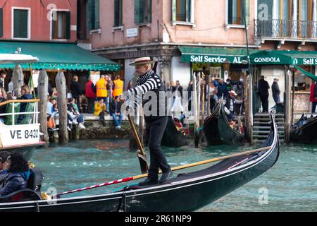 Venedig, Italien - 2. April 2022: Älterer Gondoliere mit traditionellem Strohhut und blauem Band in Venedig, Italien. Stockfoto