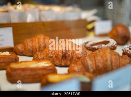 Eine köstliche Auswahl an frisch gebackenen Croissants, die in einer bezaubernden Bäckerei ausgestellt werden Stockfoto