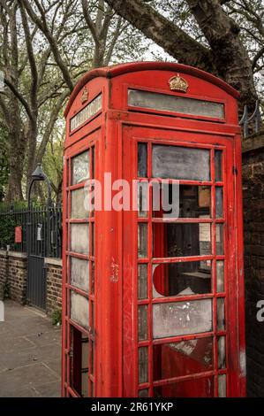 London, Vereinigtes Königreich: Eine alte Telefonzelle an der Kingsland Road in Hoxton, London. Dieser rote Telefonkiosk wurde verwüstet und das Glas ist zerbrochen. Stockfoto