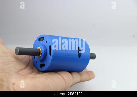 3D-bedruckter gleichstrommotor mit Doppelwelle aus PLA-Filament in der Hand Stockfoto