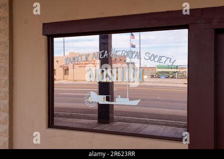 Parker, AZ - 10. März 2023: Parker Area Historical Society Museum Fenster mit weicher Fokussierung des Besucherinformationszentrums. Über die Straße Stockfoto