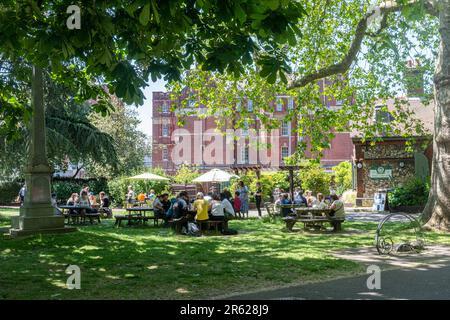 Leute, die an Tischen vor dem Cafe im Park sitzen und an einem sonnigen Sommertag Essen und Getränke genießen, Victoria Park, Portsmouth, Hampshire, England, UK Stockfoto