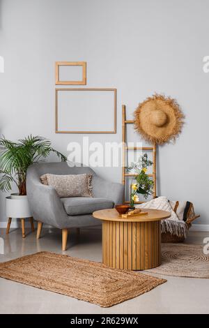 Wohnzimmereinrichtung mit Ikebana auf Tisch und Sessel Stockfoto
