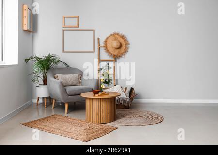 Wohnzimmereinrichtung mit Ikebana auf Tisch und Sessel Stockfoto