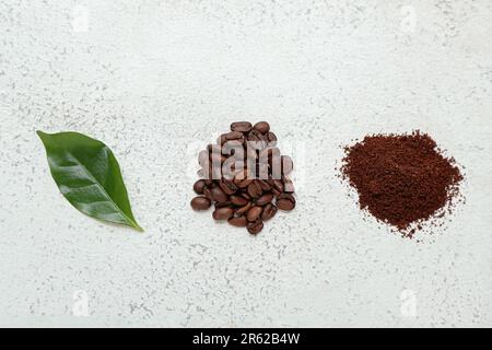 Blätter, Kaffeebohnen und Pulver auf hellem Hintergrund Stockfoto