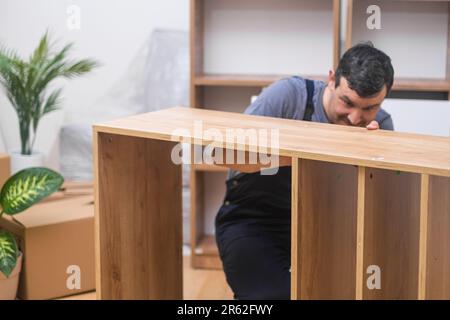 Möbellieferservice fokussiert auf Zimmermann, der Holzbohlen prüft Stockfoto