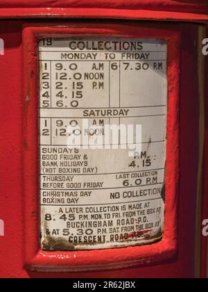 Zeitplakette auf einem roten Säulenkasten von George V (1927-1935), ausgestellt im Postal Museum in London, Großbritannien. Stockfoto
