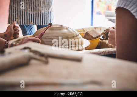 Die Textur verleiht Ihrem Kind einen Hauch von Persönlichkeit. Eine nicht wiedererkennbare Frau, die mit Ton in einem Töpferstudio arbeitet. Stockfoto