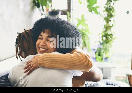 Liebe lässt deine Seele aus ihrem Versteck kriechen. Eine junge Frau umarmt ihren Freund zu Hause. Stockfoto