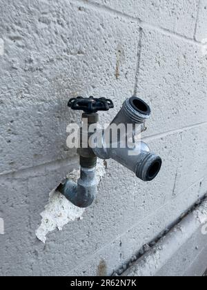 Eine detaillierte Nahaufnahme eines Metallrohrs, das an einer Wand befestigt ist, erfasst die Textur Stockfoto