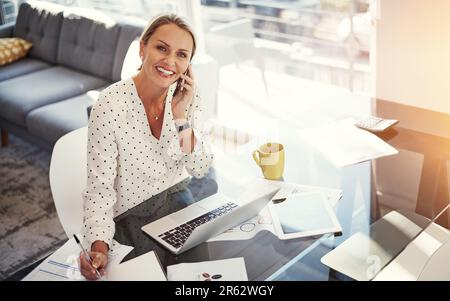 Sie nimmt den ganzen Tag Anrufe entgegen, um ihr Geschäft zu unterstützen. Eine reife Geschäftsfrau, die von ihrem Heimbüro aus arbeitet. Stockfoto