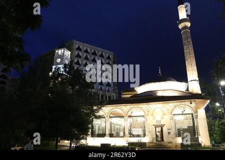 Die Hajji et'hem Bey Moschee ist eine Moschee in Tirana, Albanien. Die unter kommunistischer Herrschaft geschlossene Moschee wurde 1991 als Gotteshaus wiedereröffnet. Ohne Genehmigung der Behörden waren 10.000 Personen anwesend, und die Polizei hat sich nicht eingemischt. Fresken im Freien und im Säulenbereich stellen Bäume, Wasserfälle und Brücken dar. Auf der linken Seite befindet sich der Uhrenturm von Tirana, der 1822 in Tirana, Albanien, von et'hem bey Mollaj, einem Bejtexhinj-Dichter, erbaut wurde, der auch die et'hem Bey Moschee neben dem Uhrenturm fertigstellte. Stockfoto