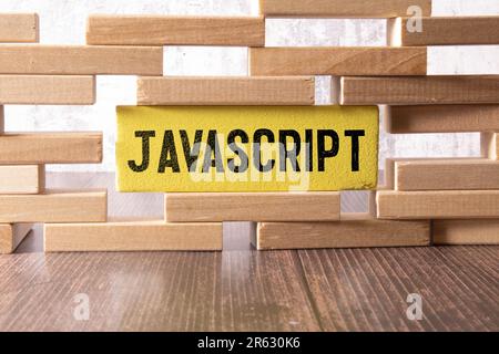 JavaScript-Programmiersprache. Papier breites Wort JavaScript und Laptop, Gläser und Kaffee auf Holztisch. Stockfoto