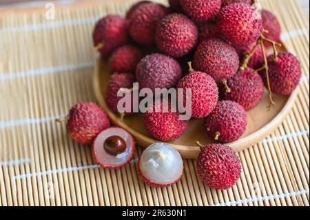 Frische, reife Lychee-Früchte tropische Früchte geschälte Litschis in Thailand, Litschis auf Holzteller Stockfoto