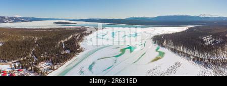 Vogelperspektive auf dem Alaska Highway im Frühling mit Schnee, Eis und gefrorenem See, die im April aufgetaut werden. Stockfoto